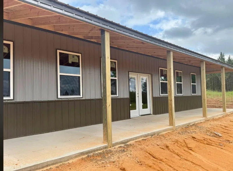 Covered porch along a two-tone barndominium with French doors and new windows