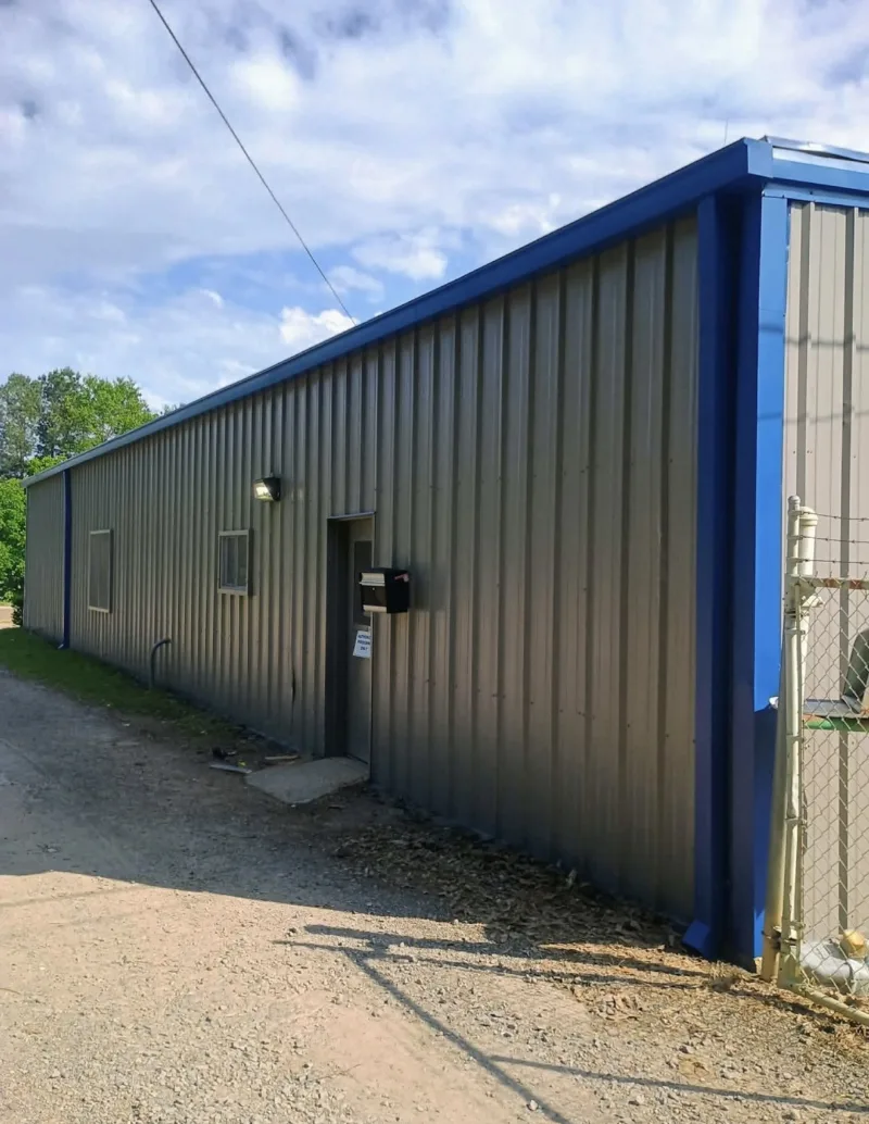 Side of a grey metal commercial building with blue trim