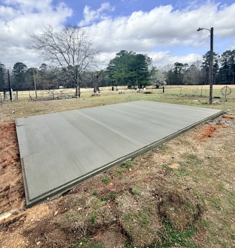 Finished concrete slab in an open pasture under a partly cloudy sky