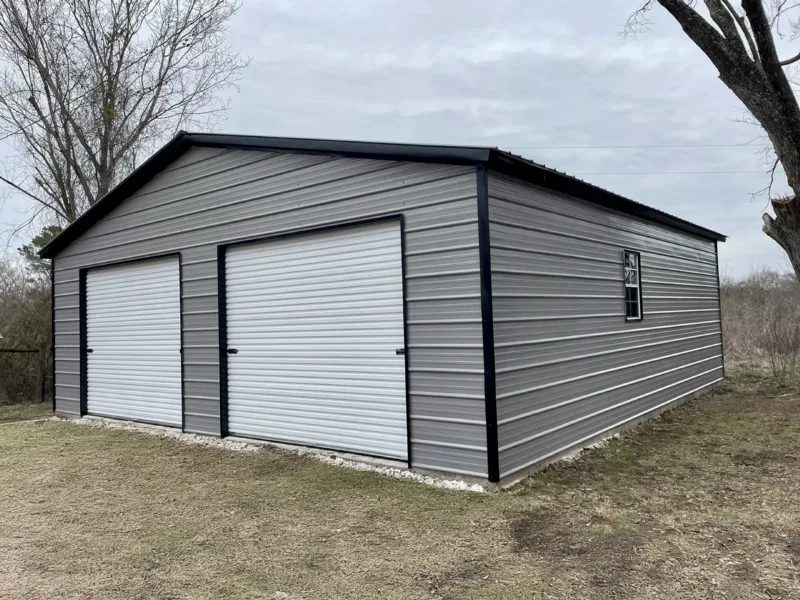 Grey metal garage with black trim and two roll-up doors