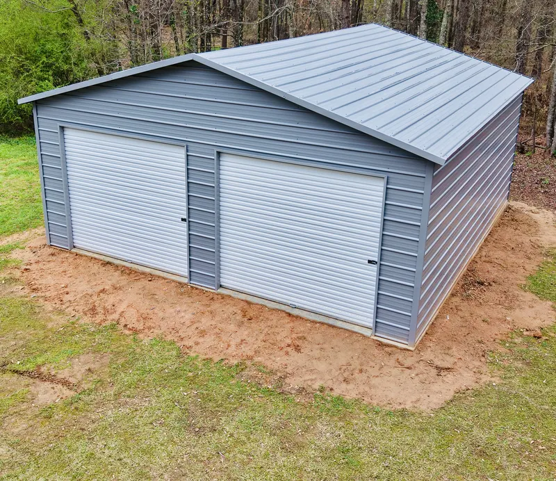 Grey metal garage with two white roll-up doors, seen from above