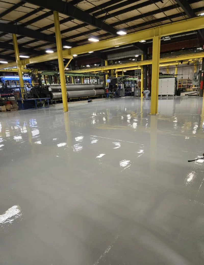 Glossy coated floor in an industrial building with yellow steel columns