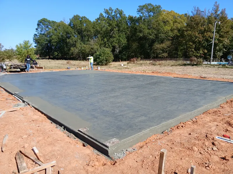 Wide freshly poured concrete slab on a prepared building pad