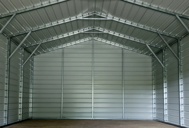 Inside an unfinished metal building showing the frame and wall panels