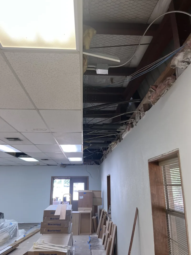 Drop ceiling grid going in above a freshly painted office wall