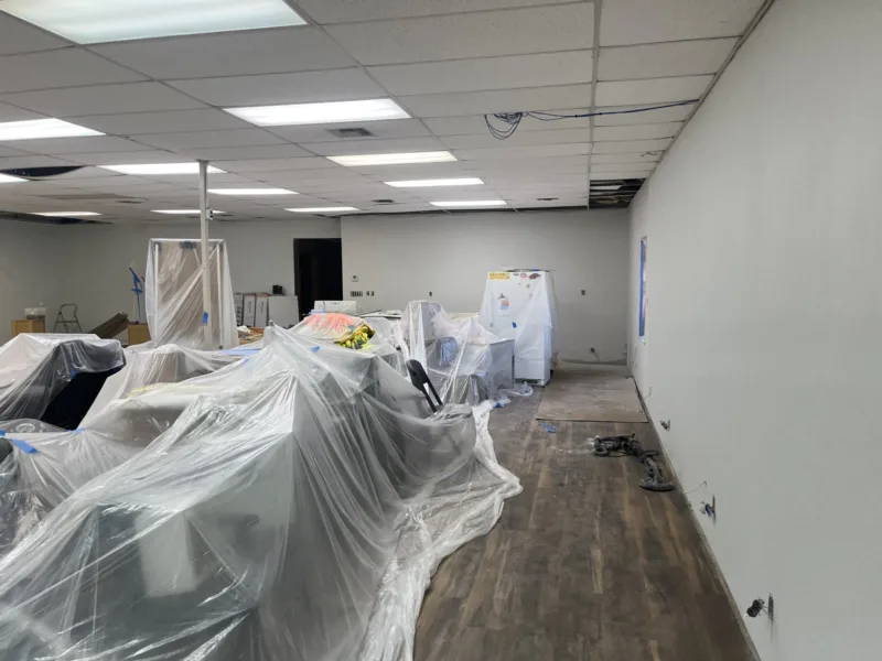 Office build-out with new plank flooring and furniture under plastic