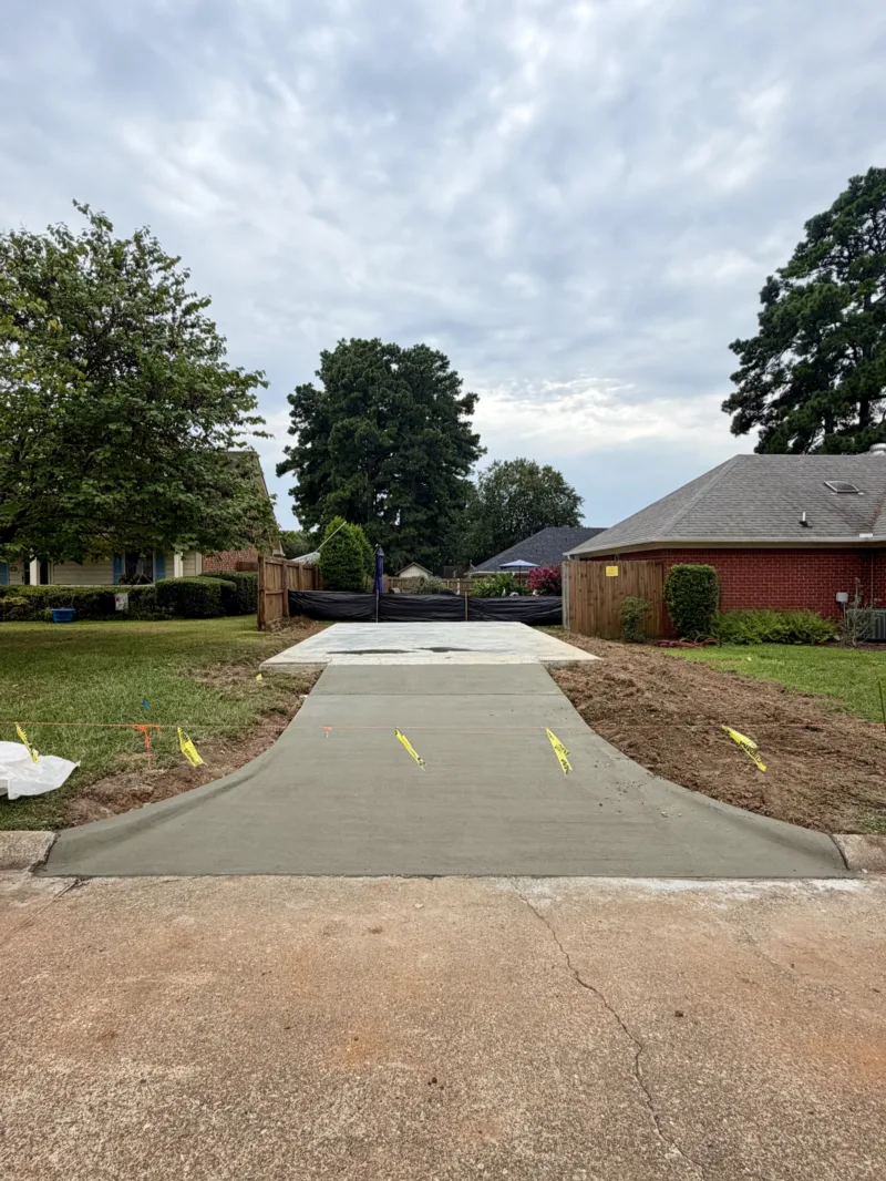 New concrete driveway running up to a brick house