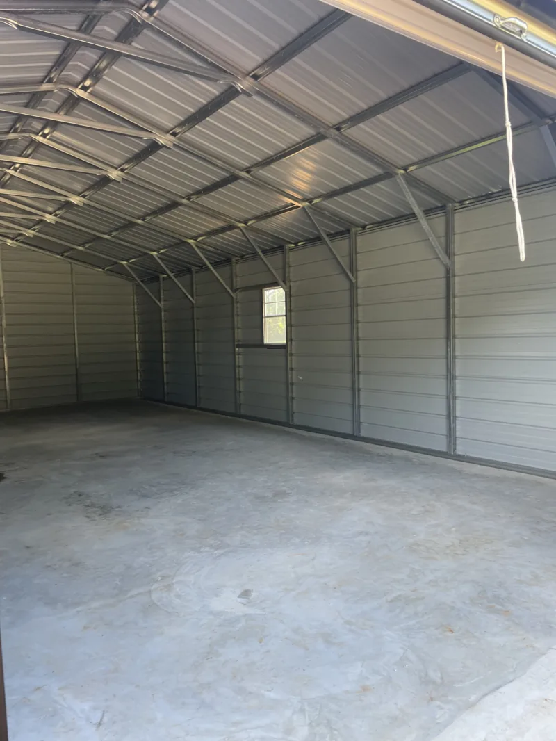 Inside a metal shop on a finished concrete slab, with a window in the end wall