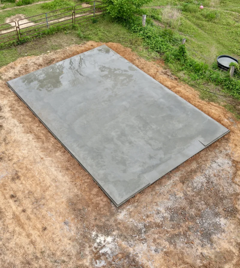 Freshly poured slab on a red dirt pad, seen from above
