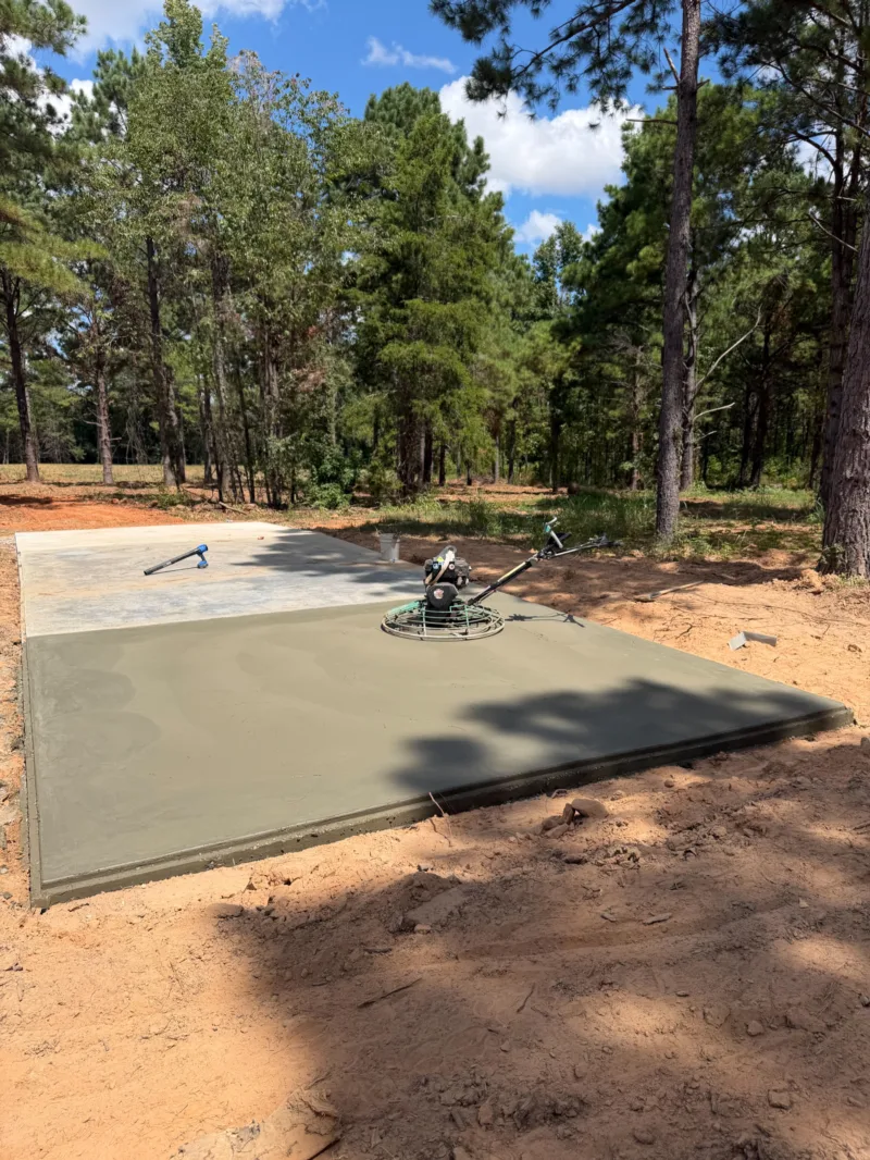 Power trowel finishing a fresh slab in a pine clearing