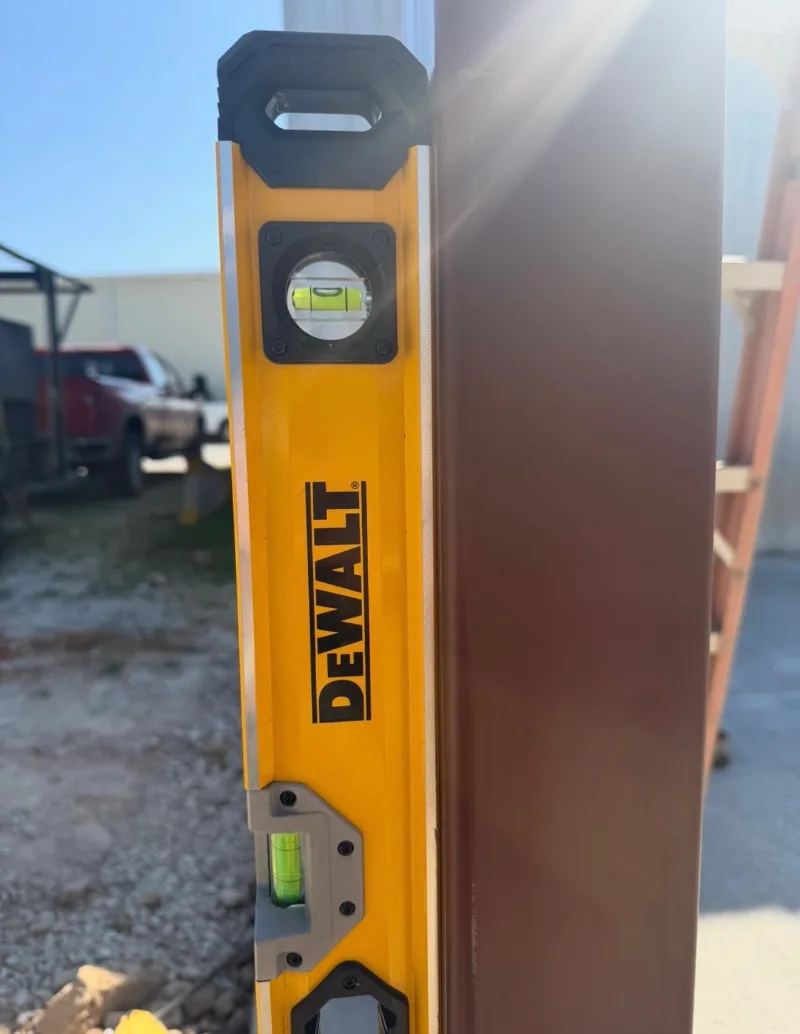 Box level held against a brown painted steel column, bubble centred