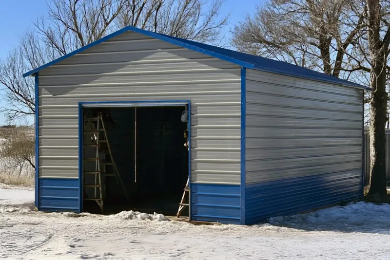 Tan metal garage with blue trim and wainscot, roll-up door open