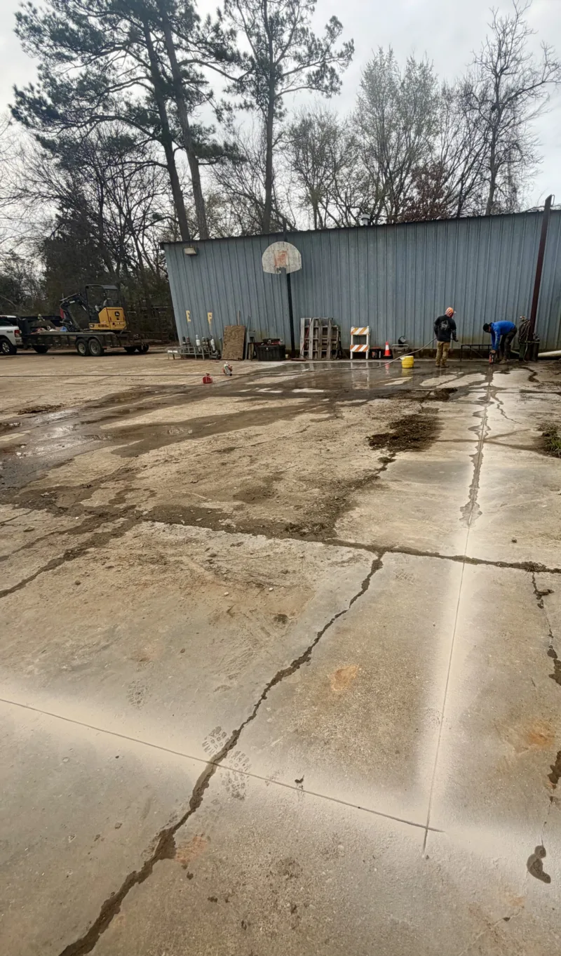 Cracked, worn concrete at a commercial lot before replacement